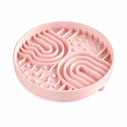 Pink silicone pet slow feeder bowl on white background, with raised maze channels and textured bumps to help pets slow down eating.